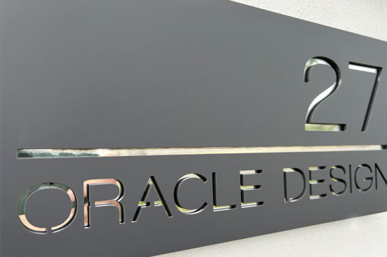 The Oracle Design external sign showing the number address on a grey backdrop